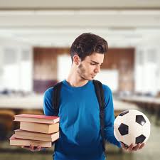 A student with a stack of books in one hand an a soccer ball in the other. They appear to be choosing whether to pursue their education or their sport. 
